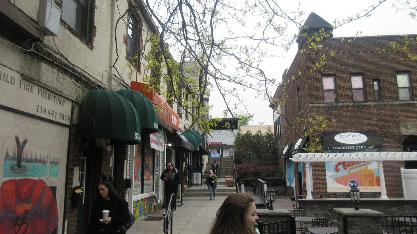 A narrow alleyway running between buildings from the Kew Gardens Long Island Rail Road station toward Lefferts Boulevard in Queens, New York